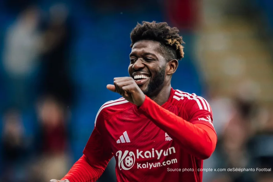 Adama Sangaré n'a que 16 ans, mais son nom circule déjà dans les plus grands clubs d'Europe. Le jeune prodige de l'académie Junior Élite de Bamako, surnommé « Damus » par ses proches, est dans le viseur du Red Bull Salzbourg. Et le Racing Club de Lens, qui l'observe depuis plusieurs mois, ne veut pas non plus rater l'opportunité de le tester. Une bataille de clubs pour l'une des pépites les plus excitantes du football malien de sa génération. Salzbourg prend contact avec son entourage Selon des informations exclusives, le Red Bull Salzbourg a pris contact avec l'entourage d'Adama Sangaré. Les Autrichiens, en quête permanente de talents africains à fort potentiel, supervisent depuis un certain temps la progression du jeune Malien. Un test avec le club autrichien devrait prochainement être organisé — une étape qui pourrait s'avérer décisive pour l'avenir du joueur. Si Salzbourg a parfois eu du mal à attirer des cracks maliens ces dernières années, le profil d'Adama Sangaré semble avoir convaincu les recruteurs du club. Sa technique, son intelligence de jeu et sa capacité à créer le danger en font un profil rare pour son âge. Lens également dans la danse Le RC Lens, qui observe le joueur depuis un moment déjà comme révélé en exclusivité, souhaite également lui faire passer un test dans les prochains mois. Le club nordiste dispose d'un avantage non négligeable dans ce dossier : Mamadou Sangaré, le frère aîné d'Adama, évolue déjà sous les couleurs sang et or des Lensois et s'est imposé comme la coqueluche des supporters. Un lien familial qui pourrait peser lourd dans la décision finale du jeune joueur. Plus fort que son frère ? Le débat est ouvert Ce qui distingue Adama Sangaré, c'est sa polyvalence : capable de jouer des deux pieds, il excelle aussi bien comme ailier que comme milieu offensif. Sa vitesse et ses dribbles chaloupés lui permettent de déstabiliser n'importe quelle défense en un contre un. Et certains observateurs proches du football malien n'hésitent pas à affirmer qu'il pourrait dépasser son frère Mamadou — pourtant lui-même déjà convoité par les plus grosses cylindrées du football européen. Pour le Mali, l'émergence simultanée de deux frères Sangaré capables de s'imposer à ce niveau est une fierté nationale. Et pour les clubs qui suivent Adama, mieux vaut ne pas attendre trop longtemps. Fiche Joueur Nom : Adama Sangaré (surnom : Damus) Nationalité : Malienne Âge : 16 ans Poste : Ailier / Milieu offensif (ambidextre) Formation : Académie Junior Élite de Bamako Lien familial : Frère cadet de Mamadou Sangaré (RC Lens, Ligue 1) Clubs intéressés : RB Salzbourg (contact établi, test prévu), RC Lens (observation en cours, test envisagé) FAQ Qui est Adama Sangaré ? Adama Sangaré, surnommé Damus, est un ailier malien de 16 ans formé à l'académie Junior Élite de Bamako, frère cadet du milieu de Lens Mamadou Sangaré, considéré comme l'un des meilleurs joueurs de sa génération au Mali. Pourquoi le RB Salzbourg s'intéresse-t-il à lui ? Le club autrichien, réputé pour sa détection de jeunes talents africains, a été impressionné par la technique, l'intelligence de jeu et la vitesse du joueur. Un test est prévu prochainement. Le RC Lens est-il également intéressé ? Oui. Lens observe Adama depuis plusieurs mois et souhaite également l'inviter à un test. La présence de son frère Mamadou au club est un atout supplémentaire dans ce dossier. Adama Sangaré est-il meilleur que son frère Mamadou ? Certains observateurs maliens estiment qu'il pourrait dépasser son frère. À 16 ans, il impressionne par sa vitesse, ses dribbles et sa capacité à jouer des deux pieds — des qualités rares à cet âge. Quel est le poste de prédilection d'Adama Sangaré ? Il peut évoluer aussi bien comme ailier que comme milieu offensif, et joue des deux pieds, ce qui en fait un profil très polyvalent pour n'importe quel entraîneur.